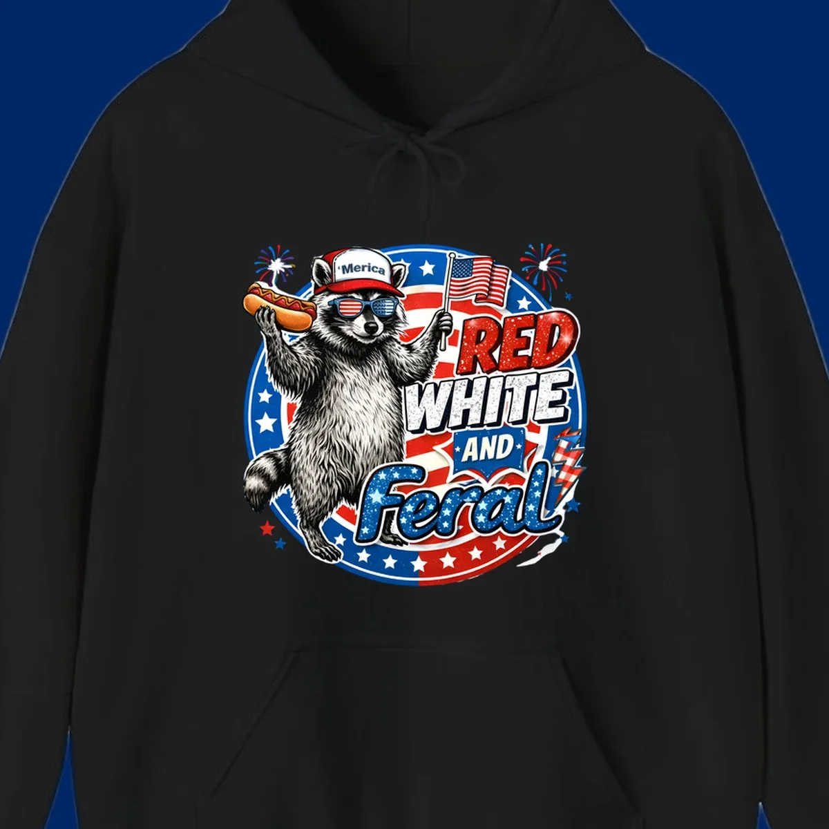 A patriotic-raccoon-feral illustration of a raccoon in a 'Merica hat, flag sunglasses, holding a hotdog and US flag. Text: RED WHITE AND Feral.