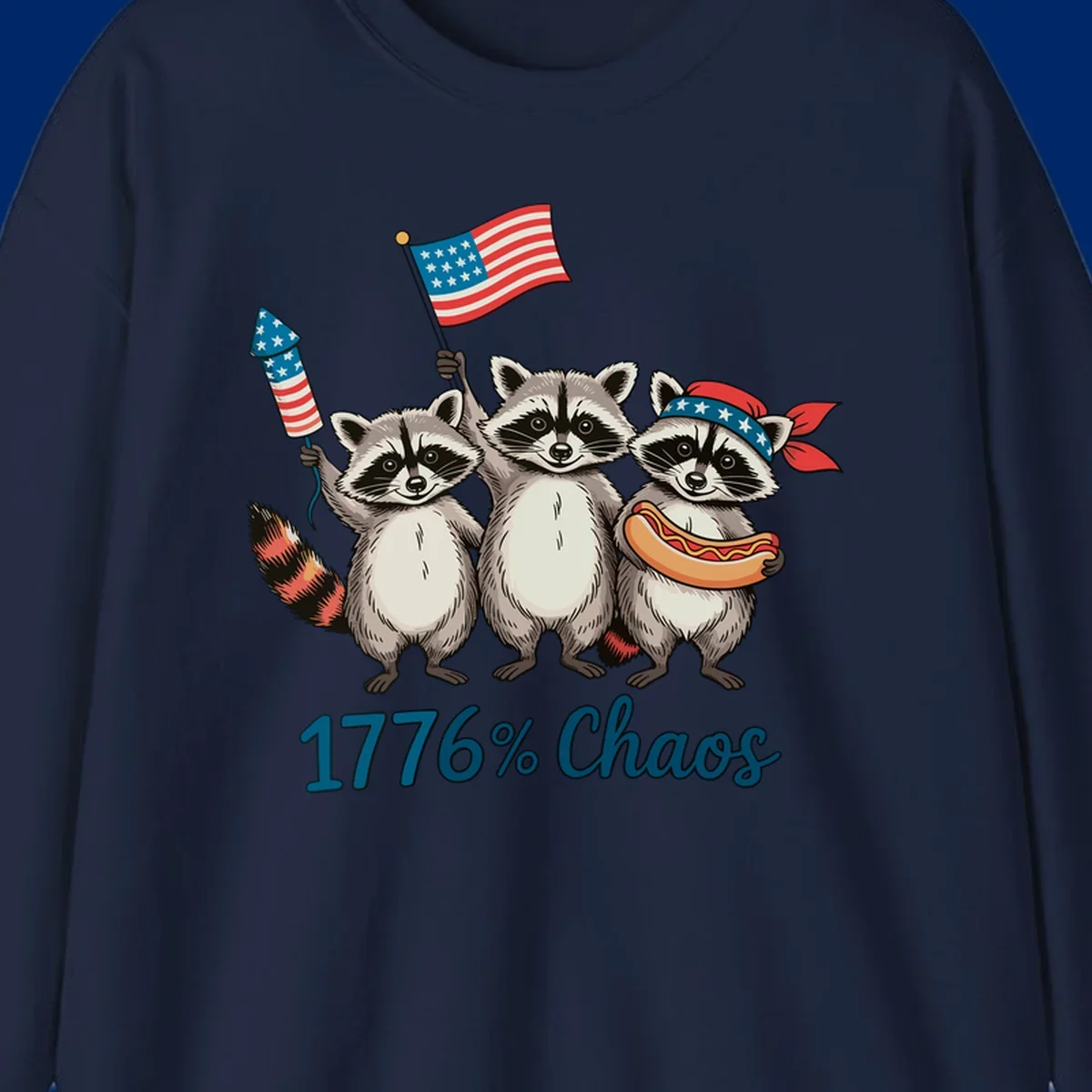 Illustration of three patriotic raccoons celebrating with an American flag, firework, and hot dog, with '1776% Chaos' text. Represents 1776-chaos-raccoons-celebration.