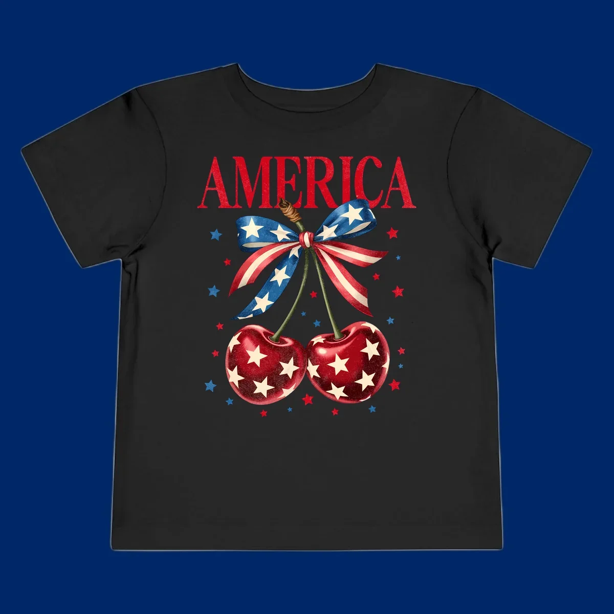Vintage patriotic artwork featuring red 'AMERICA' text, two red cherries with white stars, and an American flag ribbon. Scattered red and blue stars complete this America-cherries-stars design.
