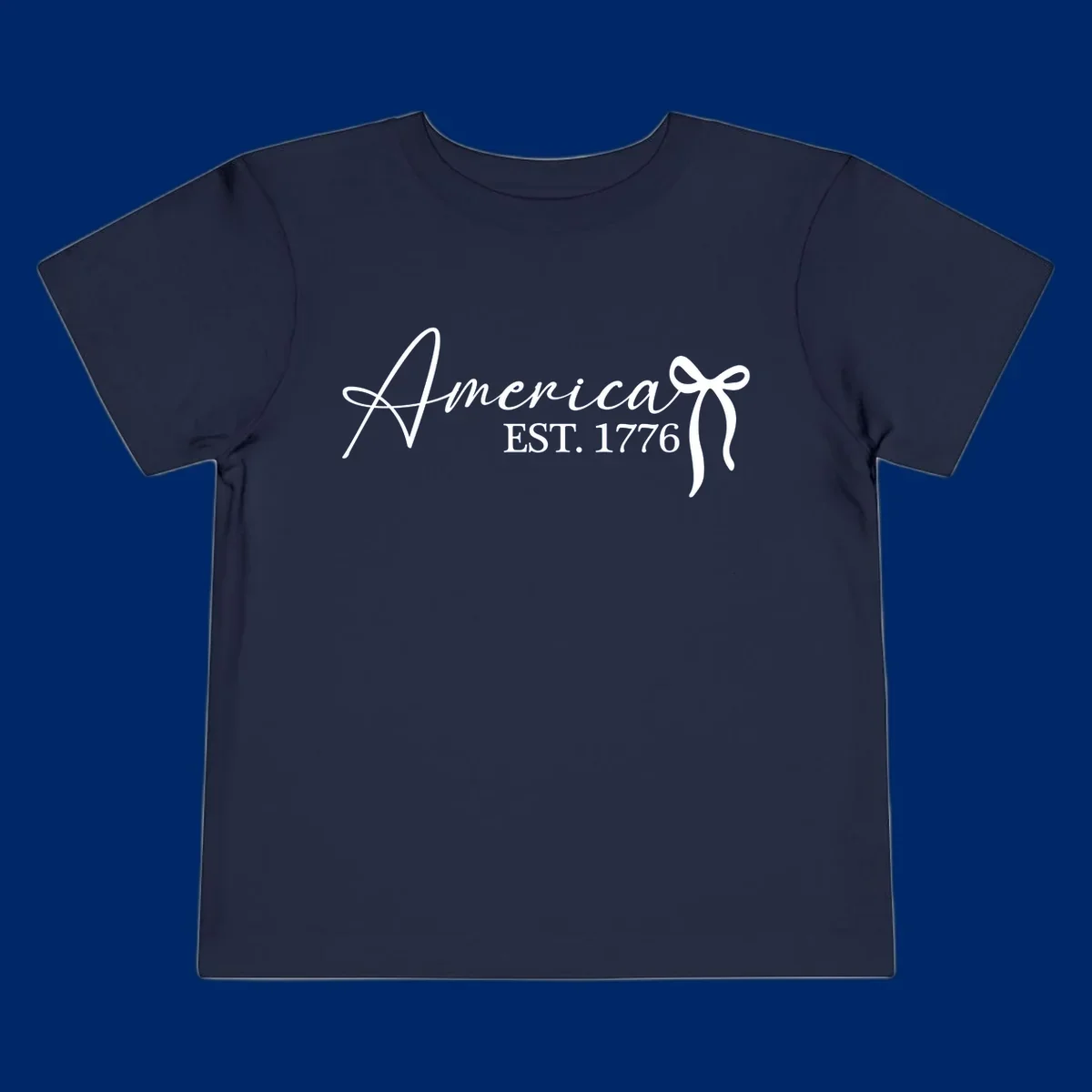 White script text "America" with decorative flourishes above "EST. 1776" in serif font, on a black background. Design for america-est-1776.