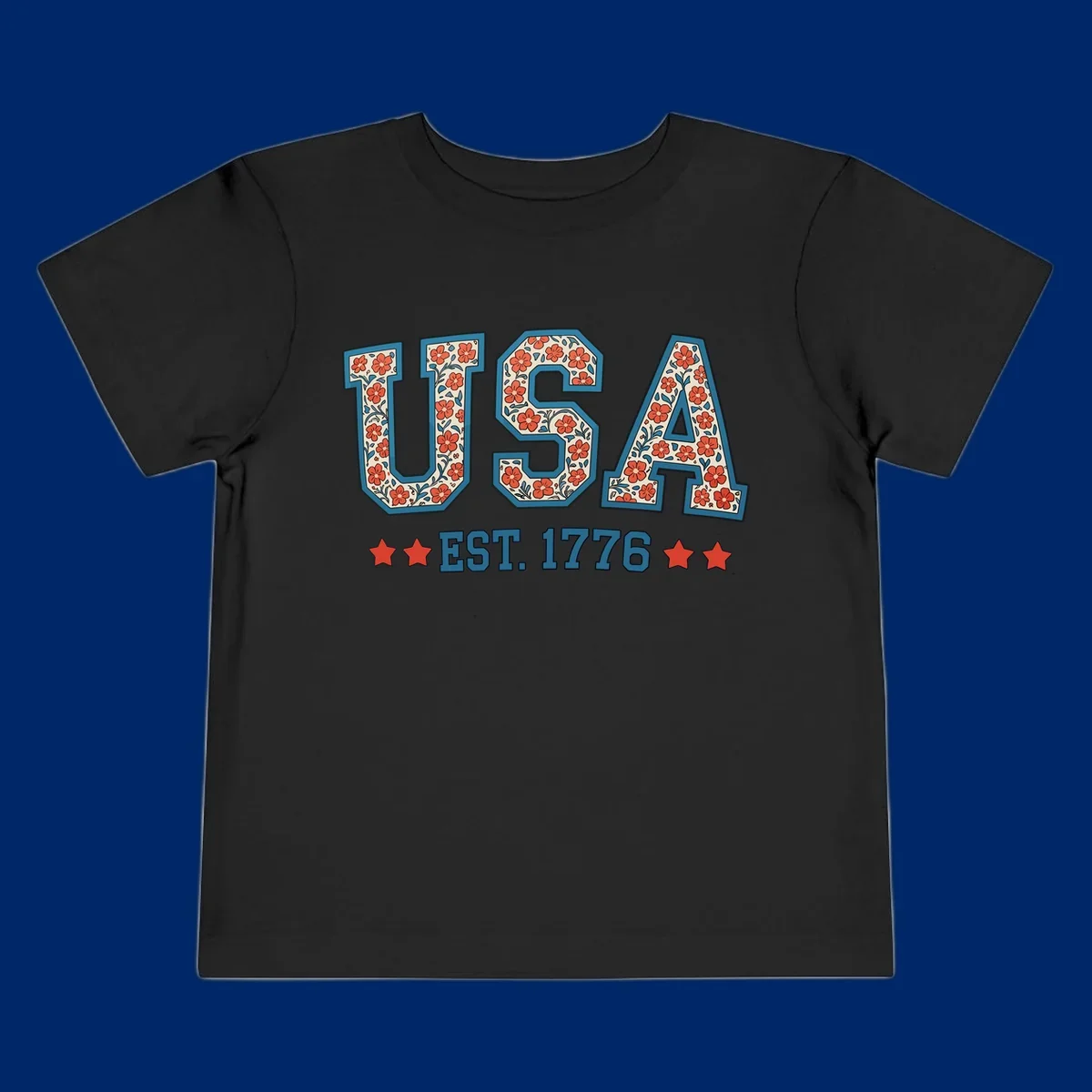 Illustrated text 'USA' with red flowers and blue leaves, above blue 'EST. 1776' text flanked by red stars. Concept: usa-est-1776-floral.