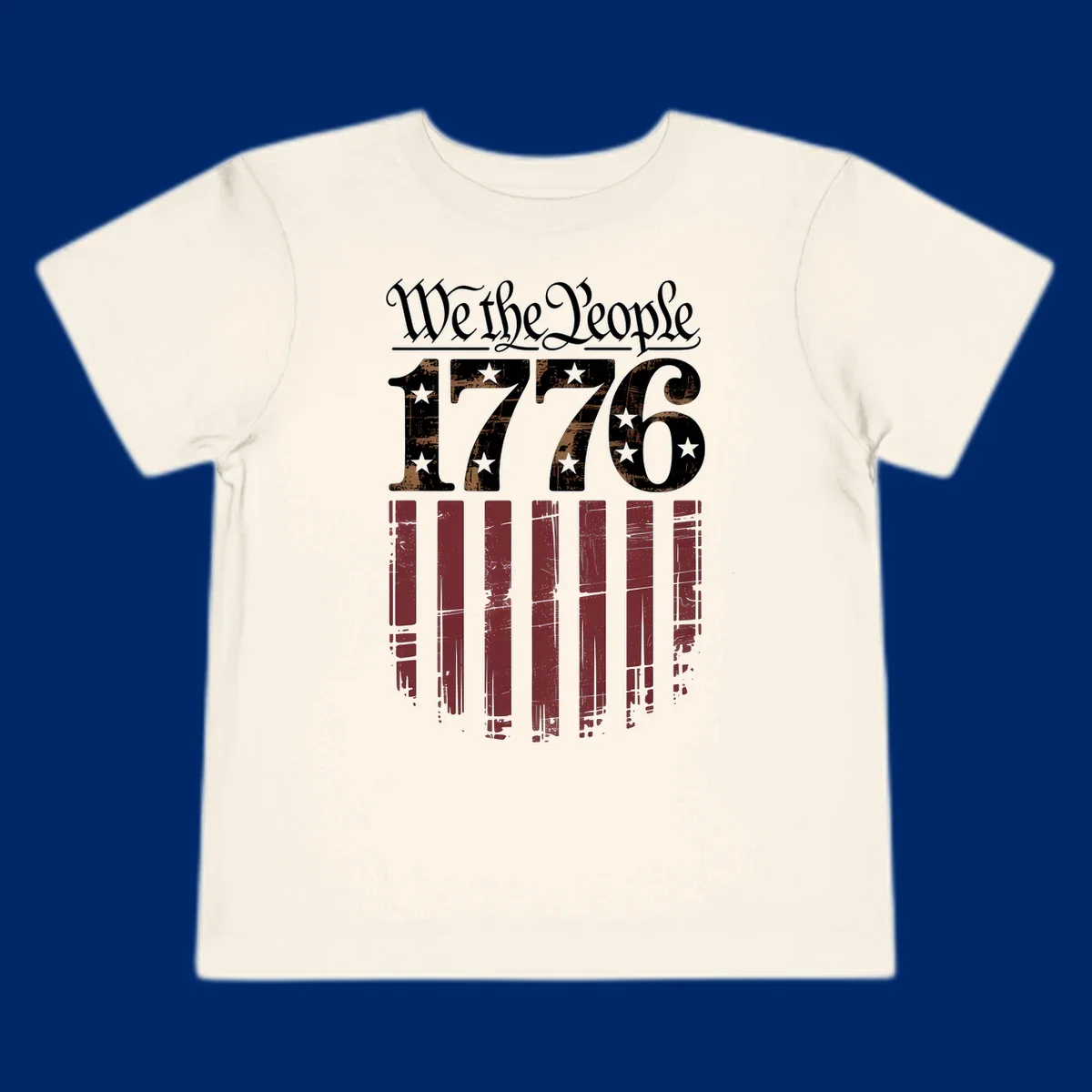 A distressed patriotic design featuring 'We the People' in script, '1776' with stars, and red stripes below, embodying the we-the-people-1776-flag theme.