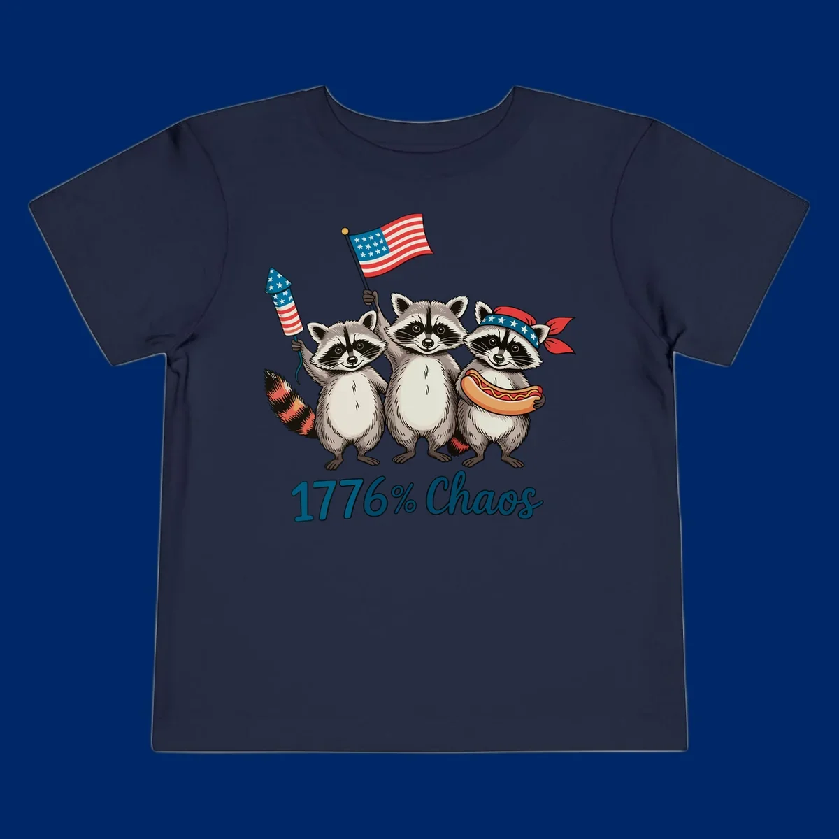 Illustration of three patriotic raccoons celebrating with an American flag, firework, and hot dog, with '1776% Chaos' text. Represents 1776-chaos-raccoons-celebration.