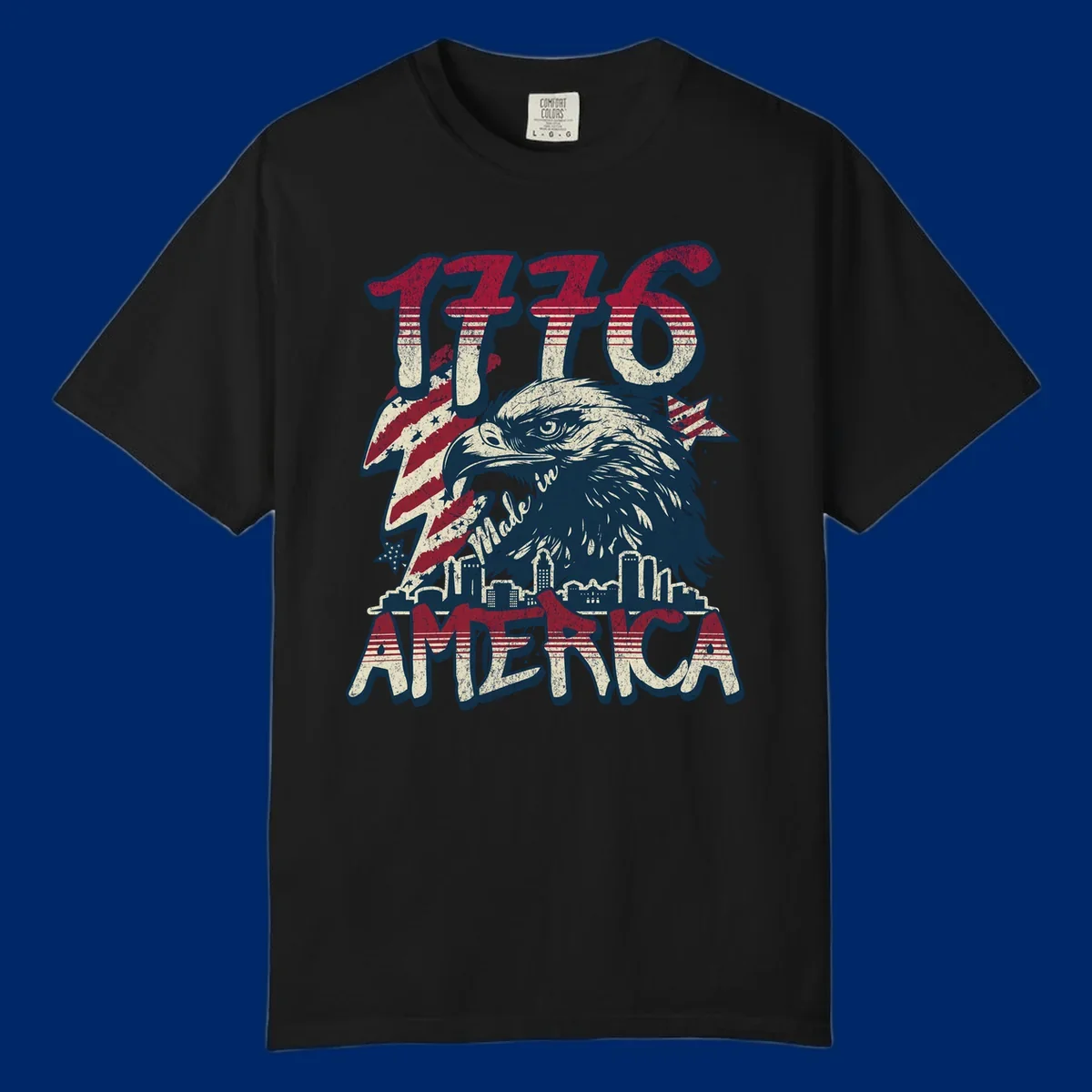 Vintage 1776 Made in America design with a bald eagle, city skyline, and American flag pattern. Features distressed red, cream, and navy colors.