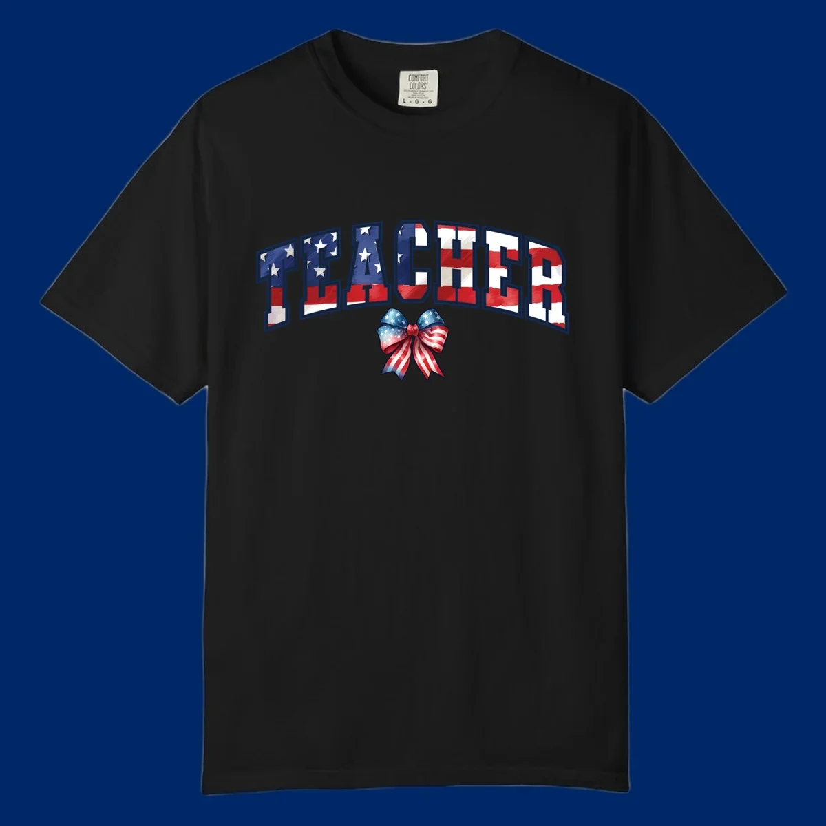 The word TEACHER in arched letters filled with an American flag pattern, featuring stars and stripes, with a patriotic bow below. Primary keyword root: patriotic-teacher-bow.