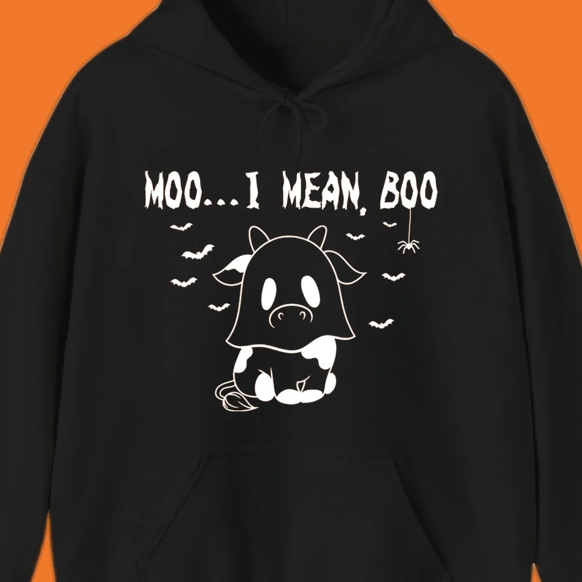 Illustration of a cow dressed as a ghost saying Moo... I mean, Boo, with bats and a spider. Moo-boo-cow.