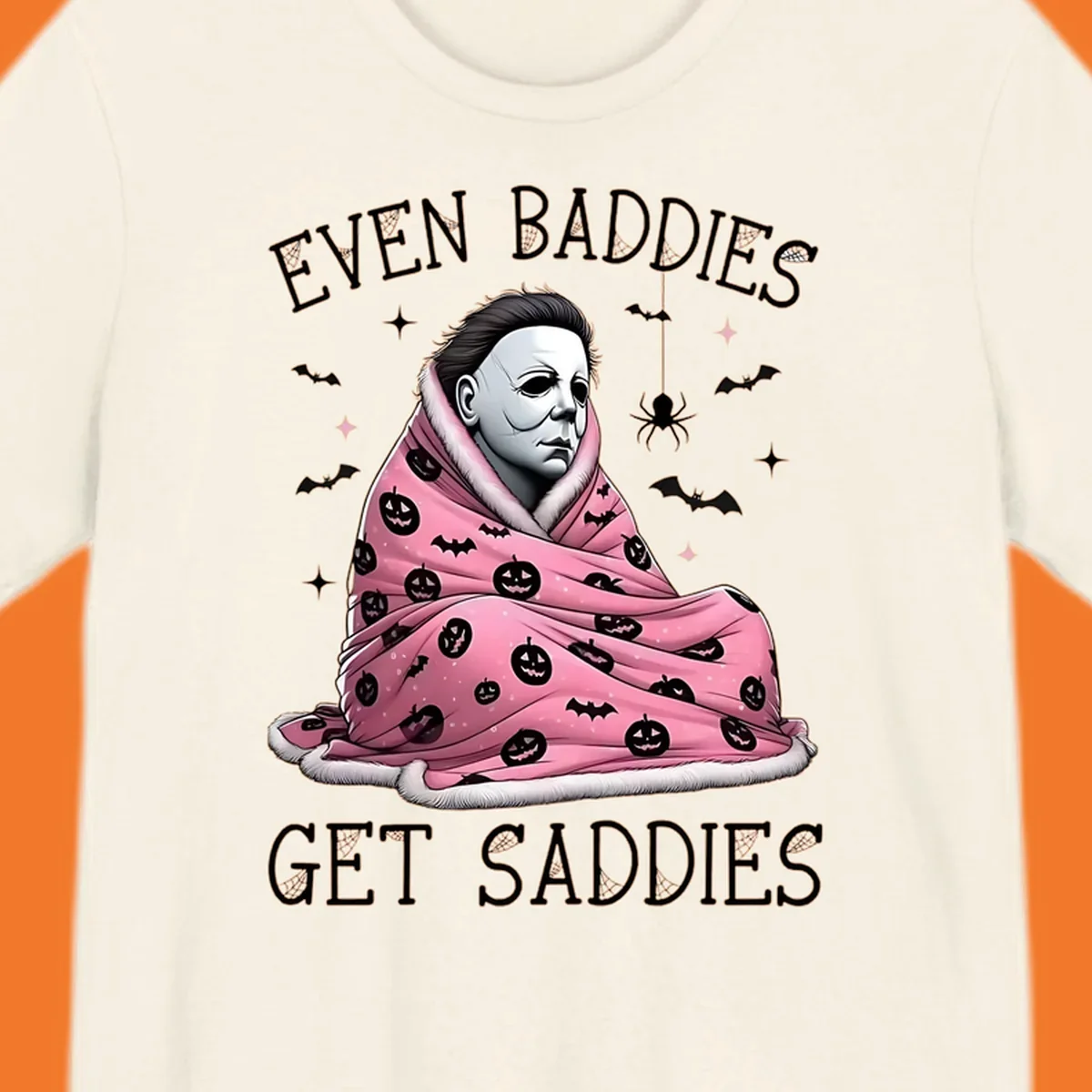Michael Myers in a pink pumpkin blanket with text 'EVEN BADDIES GET SADDIES', for the michael-myers-cozy concept.