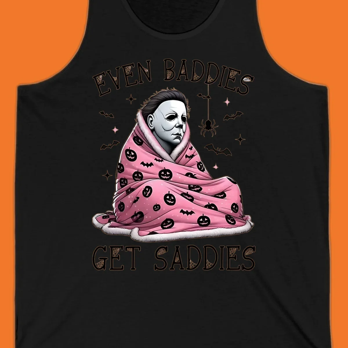 Michael Myers in a pink pumpkin blanket with text 'EVEN BADDIES GET SADDIES', for the michael-myers-cozy concept.