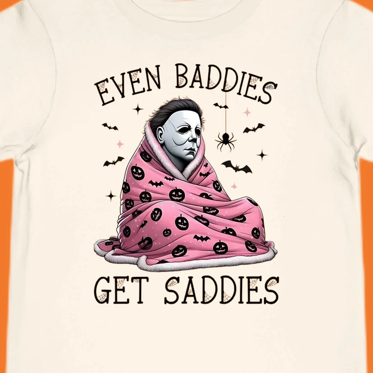 Michael Myers in a pink pumpkin blanket with text 'EVEN BADDIES GET SADDIES', for the michael-myers-cozy concept.