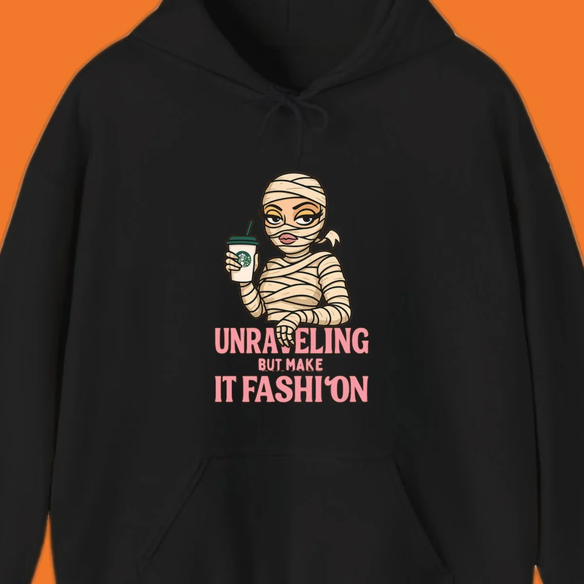 Mummy holding coffee cup with 'Unraveling But Make It Fashion' text. Mummy-fashion-coffee.