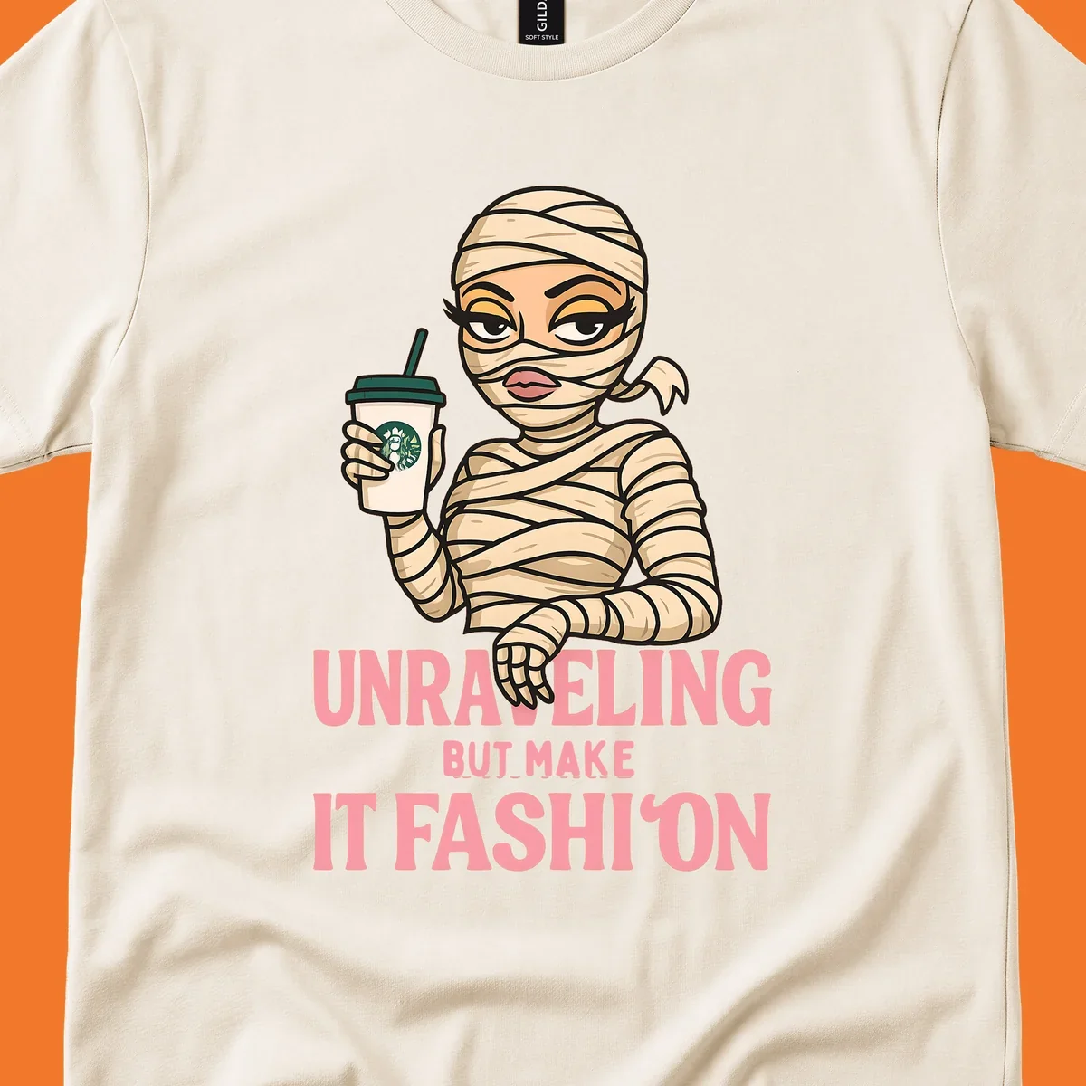Mummy holding coffee cup with 'Unraveling But Make It Fashion' text. Mummy-fashion-coffee.