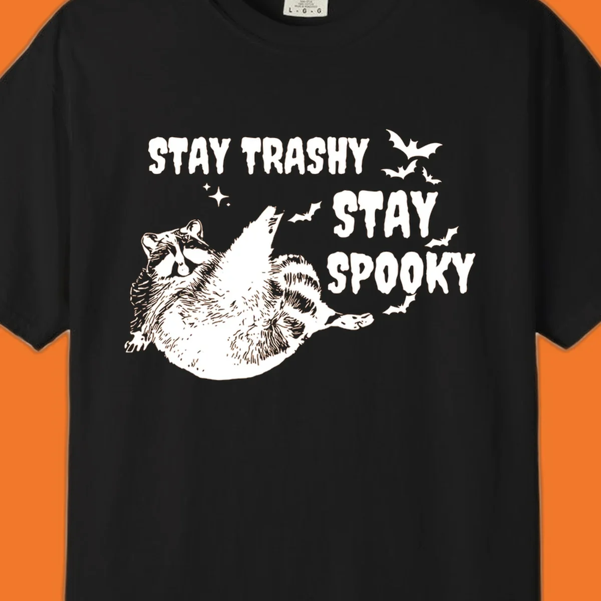 Trashy spooky raccoon illustration with bats and text for Halloween.