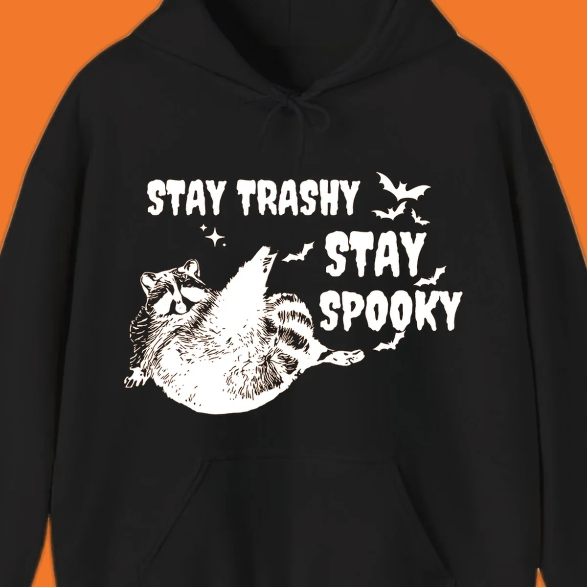 Trashy spooky raccoon illustration with bats and text for Halloween.