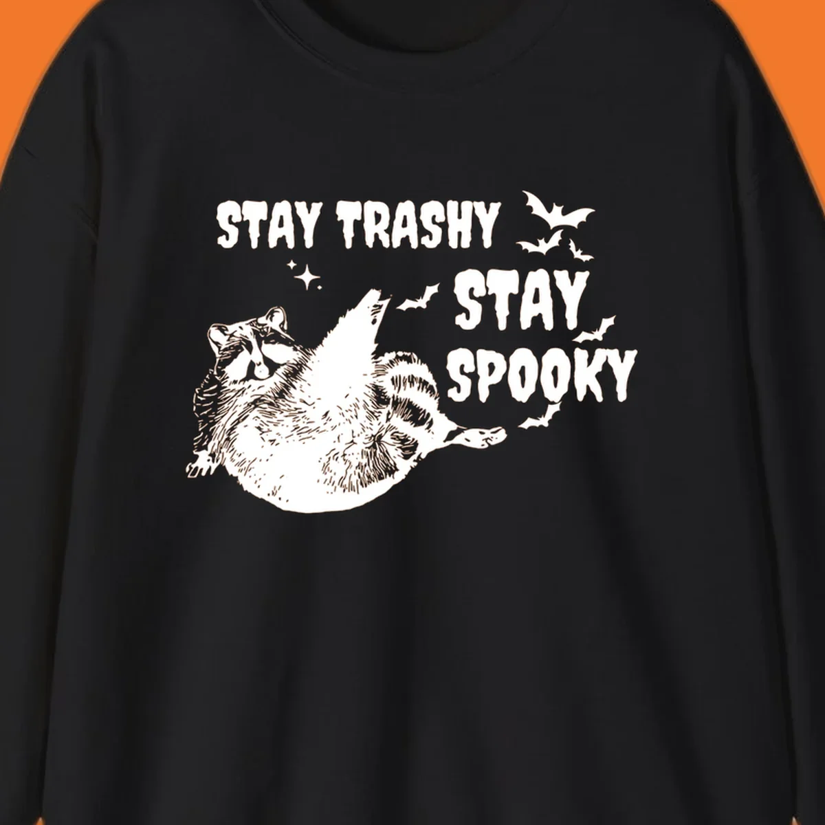 Trashy spooky raccoon illustration with bats and text for Halloween.