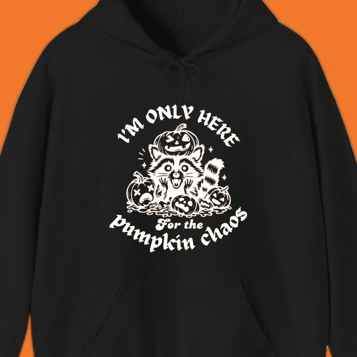 Illustration of a raccoon surrounded by pumpkins, text says 'I'm Only Here For The Pumpkin Chaos'.