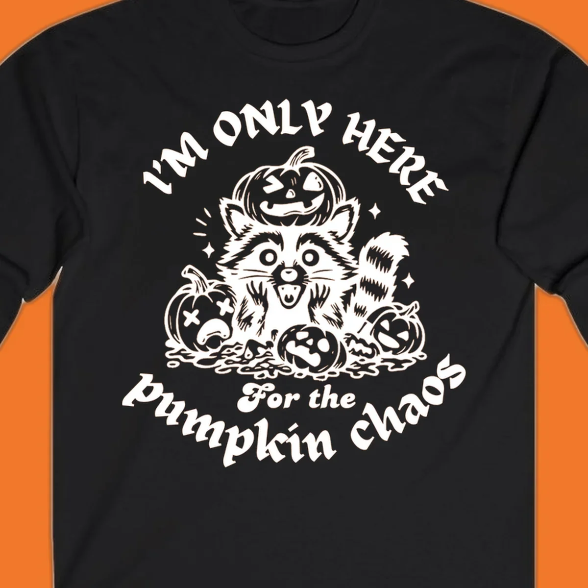 Illustration of a raccoon surrounded by pumpkins, text says 'I'm Only Here For The Pumpkin Chaos'.