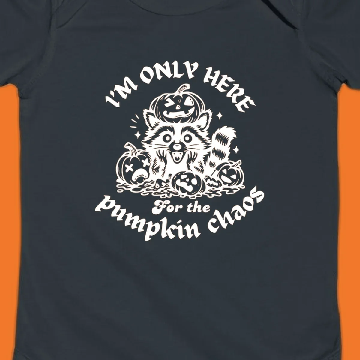 Illustration of a raccoon surrounded by pumpkins, text says 'I'm Only Here For The Pumpkin Chaos'.