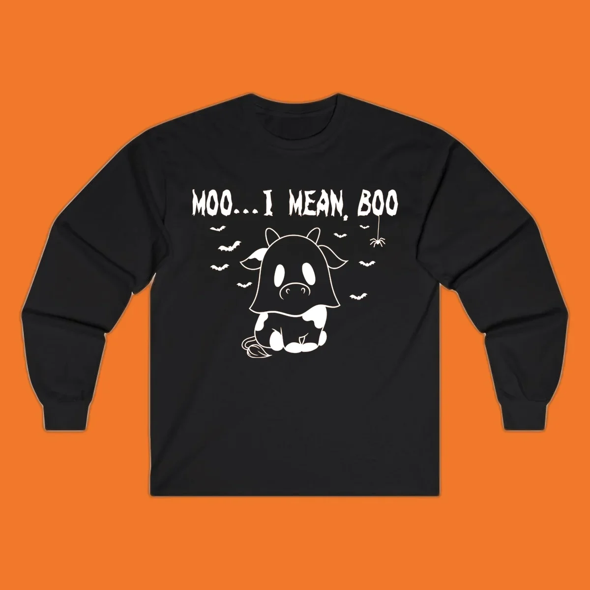 Illustration of a cow dressed as a ghost saying Moo... I mean, Boo, with bats and a spider. Moo-boo-cow.
