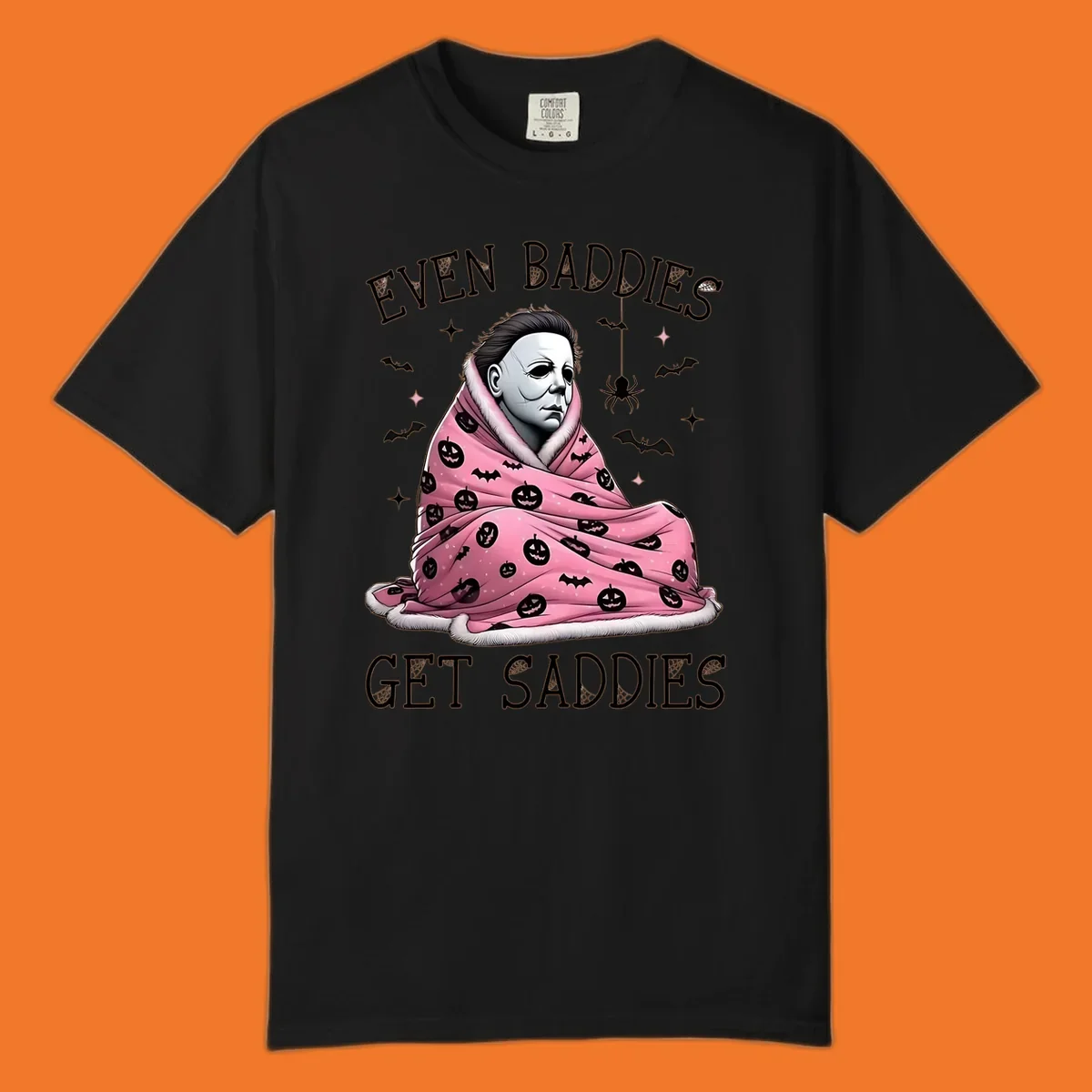 Michael Myers in a pink pumpkin blanket with text 'EVEN BADDIES GET SADDIES', for the michael-myers-cozy concept.