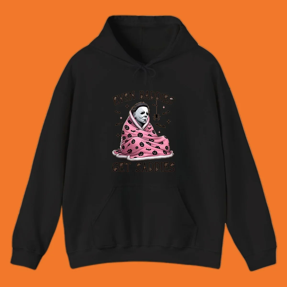 Michael Myers in a pink pumpkin blanket with text 'EVEN BADDIES GET SADDIES', for the michael-myers-cozy concept.