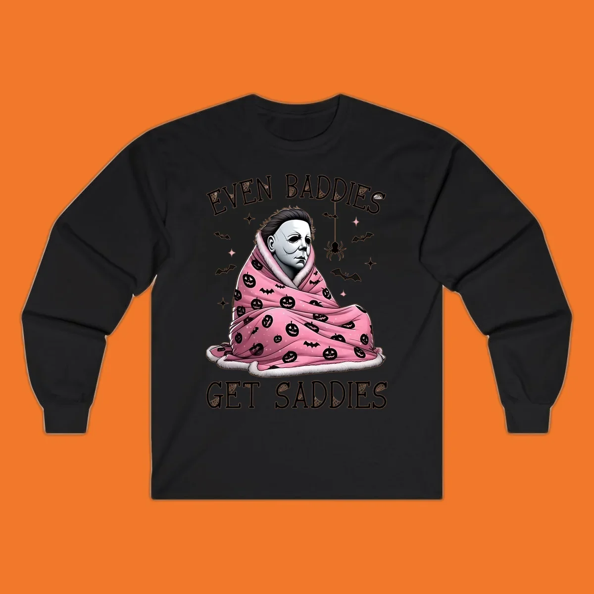 Michael Myers in a pink pumpkin blanket with text 'EVEN BADDIES GET SADDIES', for the michael-myers-cozy concept.