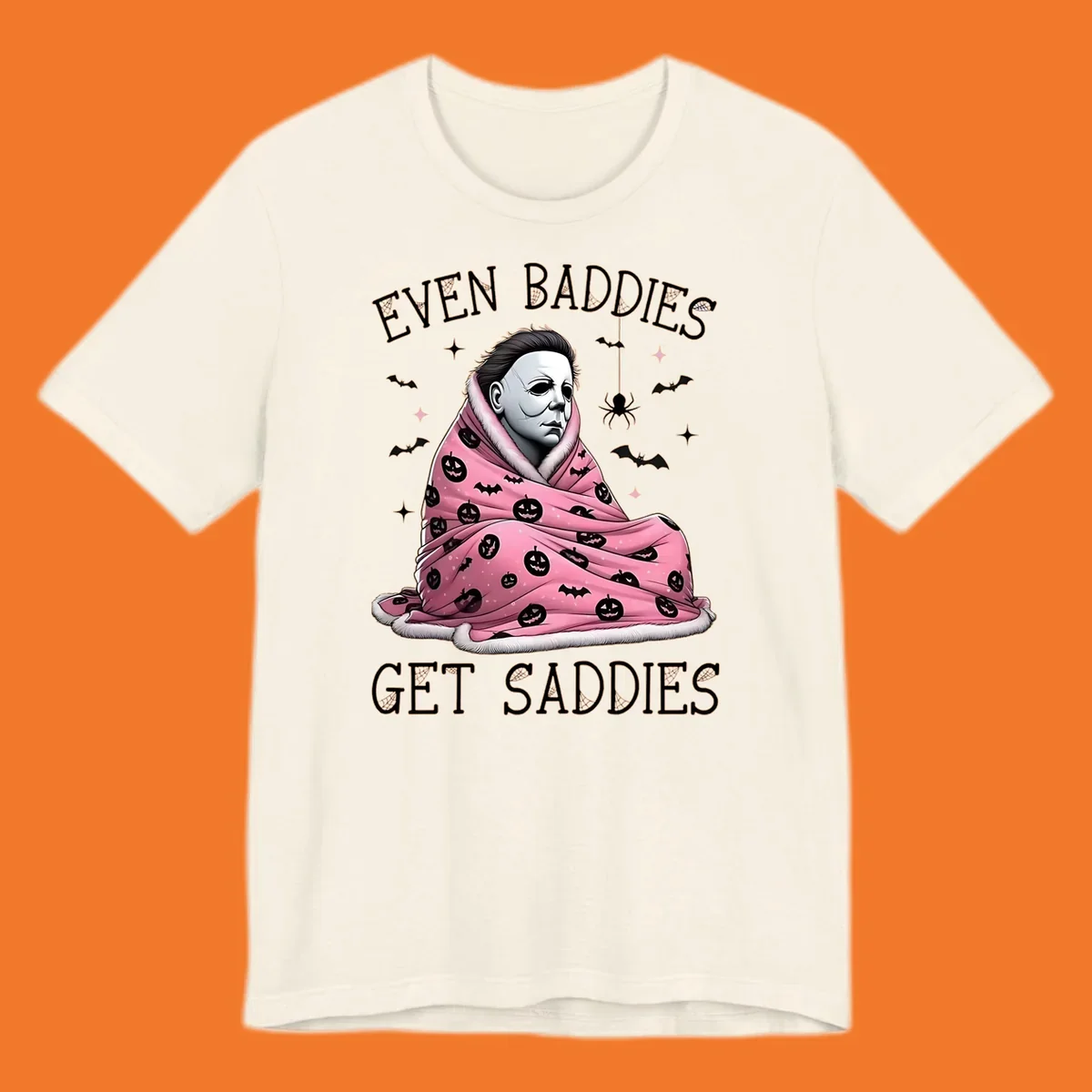Michael Myers in a pink pumpkin blanket with text 'EVEN BADDIES GET SADDIES', for the michael-myers-cozy concept.