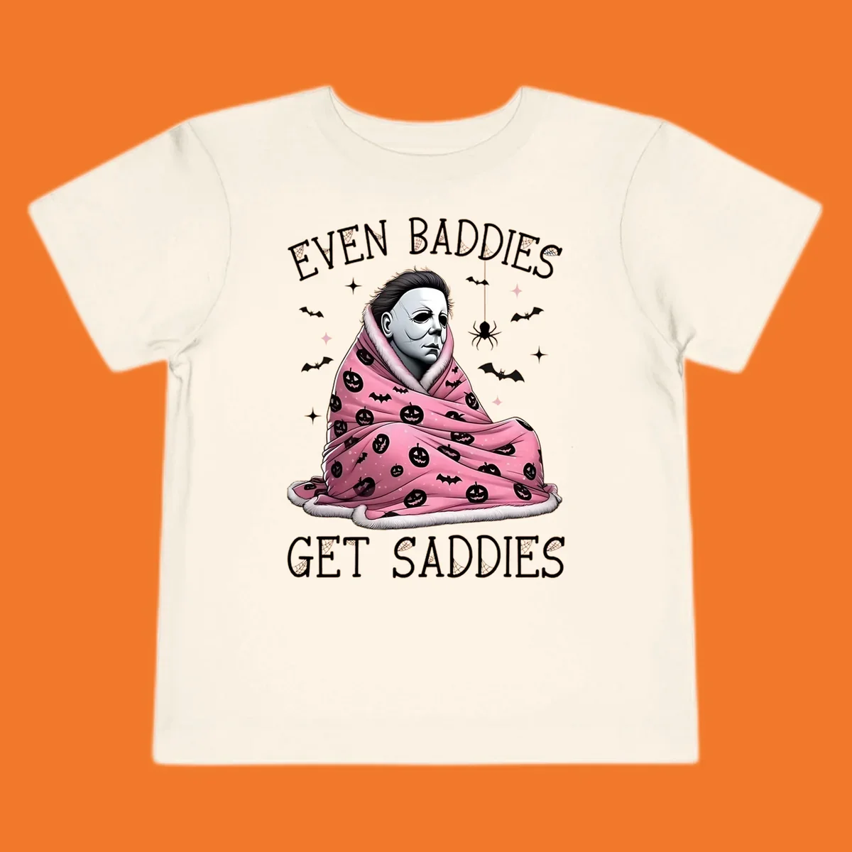 Michael Myers in a pink pumpkin blanket with text 'EVEN BADDIES GET SADDIES', for the michael-myers-cozy concept.