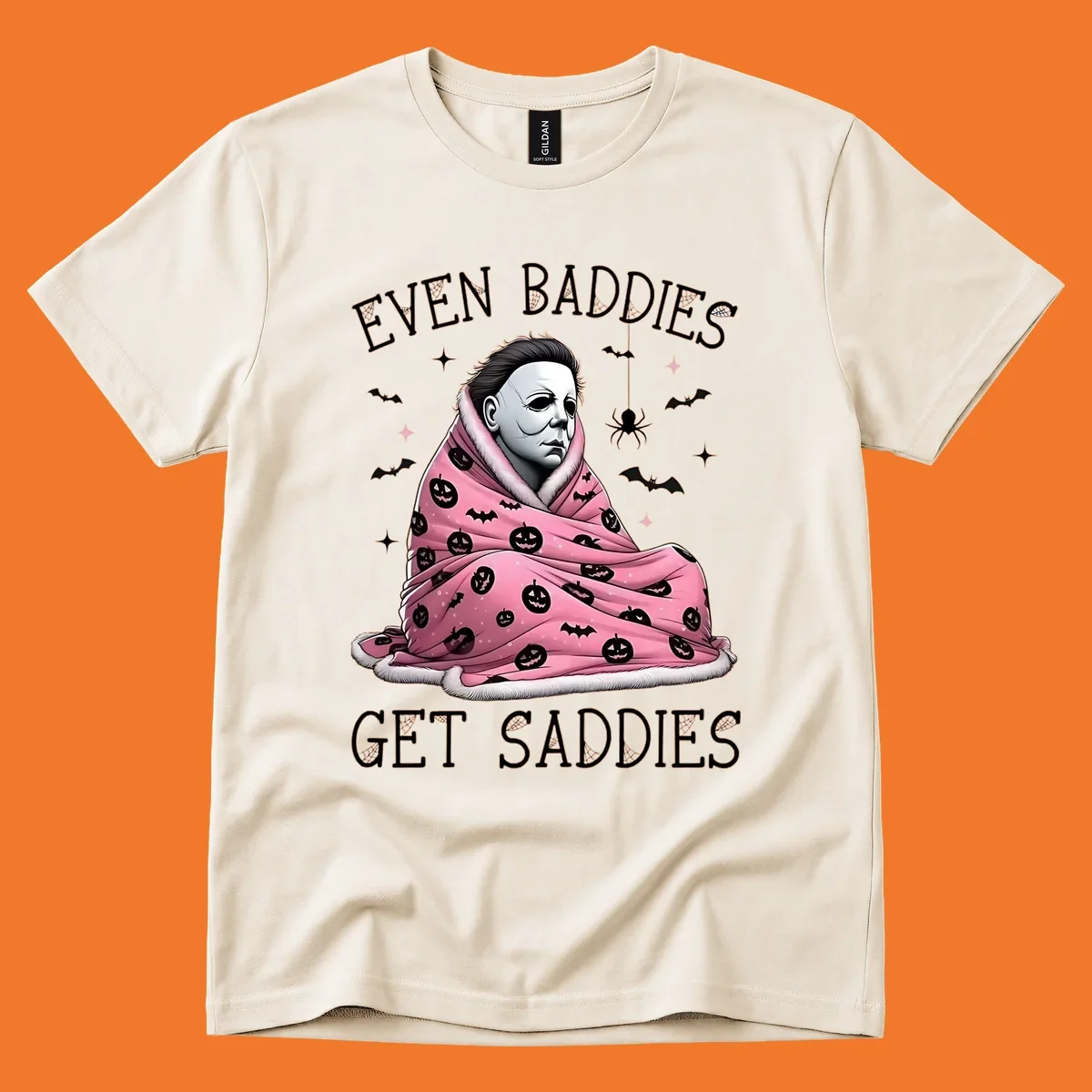 Michael Myers in a pink pumpkin blanket with text 'EVEN BADDIES GET SADDIES', for the michael-myers-cozy concept.
