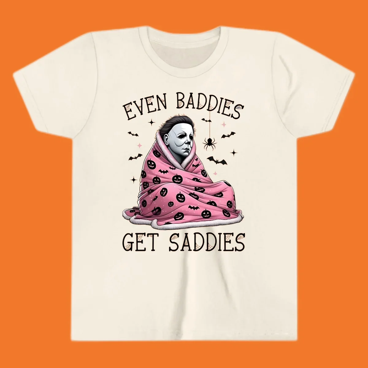 Michael Myers in a pink pumpkin blanket with text 'EVEN BADDIES GET SADDIES', for the michael-myers-cozy concept.
