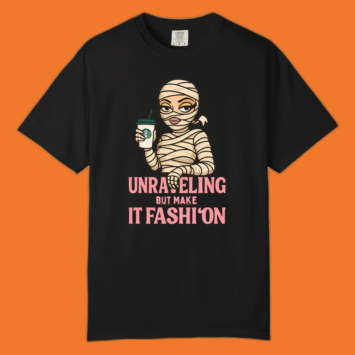 Mummy holding coffee cup with 'Unraveling But Make It Fashion' text. Mummy-fashion-coffee.