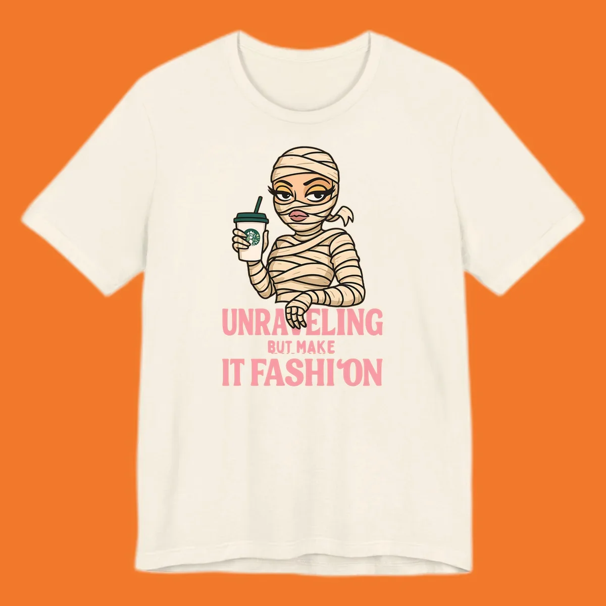 Mummy holding coffee cup with 'Unraveling But Make It Fashion' text. Mummy-fashion-coffee.