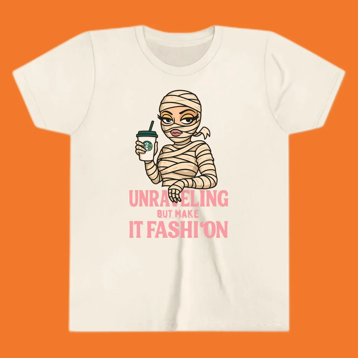 Mummy holding coffee cup with 'Unraveling But Make It Fashion' text. Mummy-fashion-coffee.