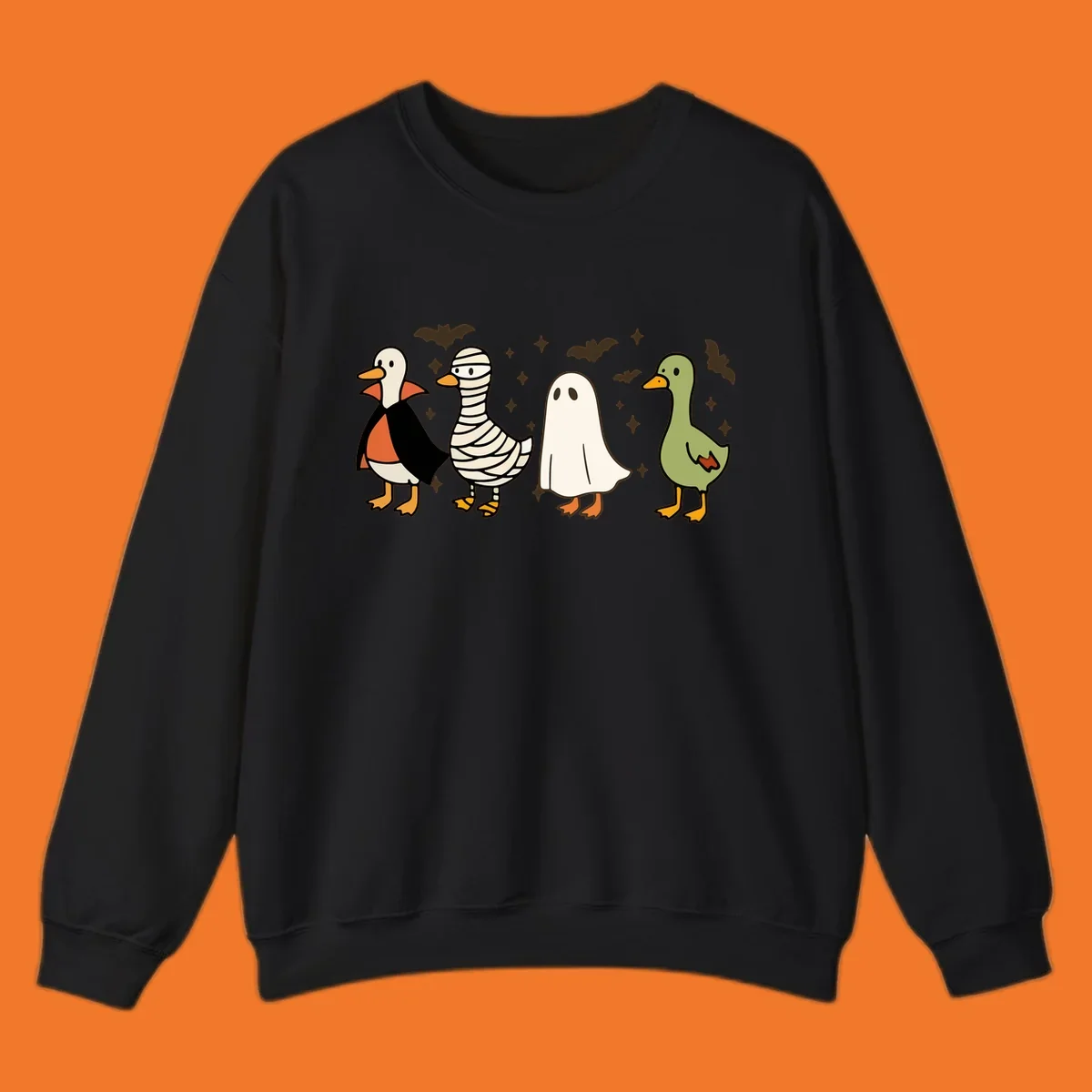 Four cute ducks in Halloween costumes: vampire, mummy, ghost, and plain duck, with bats and stars.