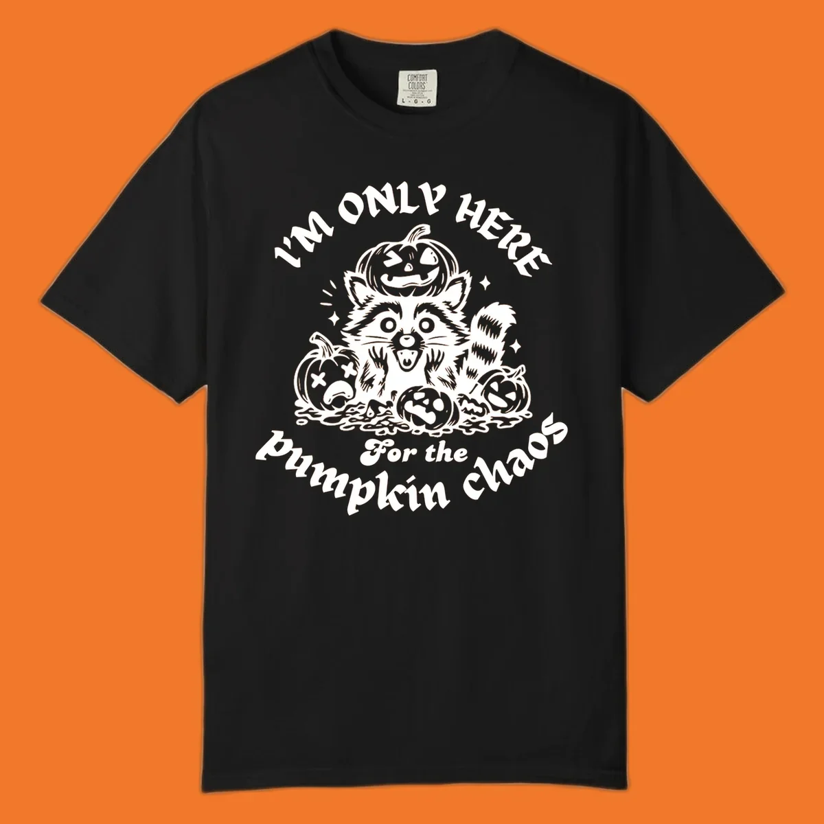 Illustration of a raccoon surrounded by pumpkins, text says 'I'm Only Here For The Pumpkin Chaos'.