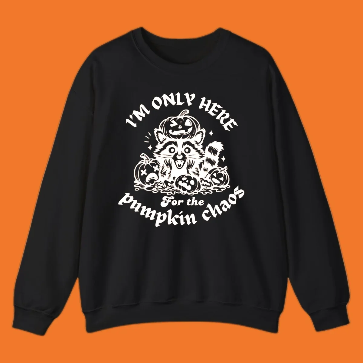 Illustration of a raccoon surrounded by pumpkins, text says 'I'm Only Here For The Pumpkin Chaos'.