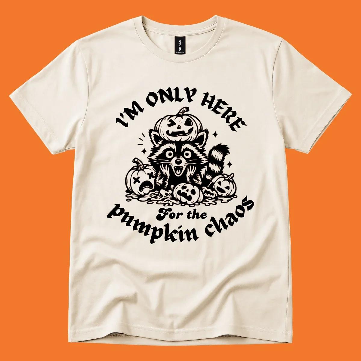 Illustration of a raccoon surrounded by pumpkins, text says 'I'm Only Here For The Pumpkin Chaos'.