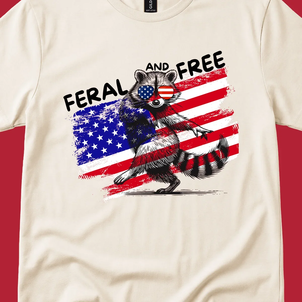 A standing raccoon with an American flag design and USA flag sunglasses, with the text 'FERAL AND FREE'. feral-free-raccoon-flag.