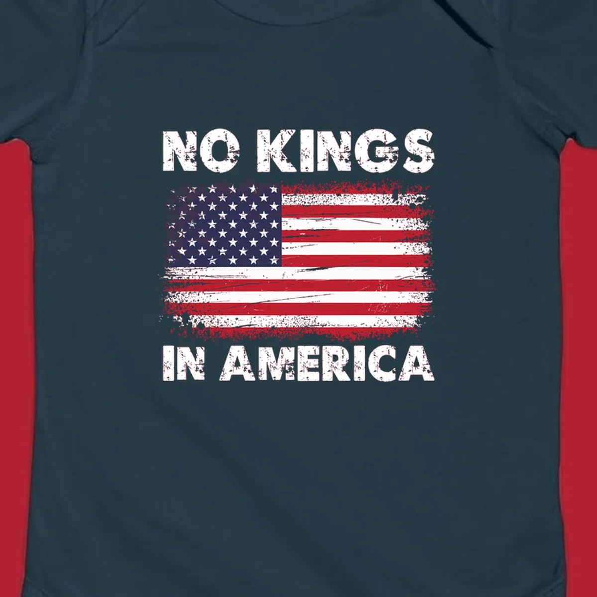 A distressed American flag with the white text 'NO KINGS IN AMERICA' above and below it.
