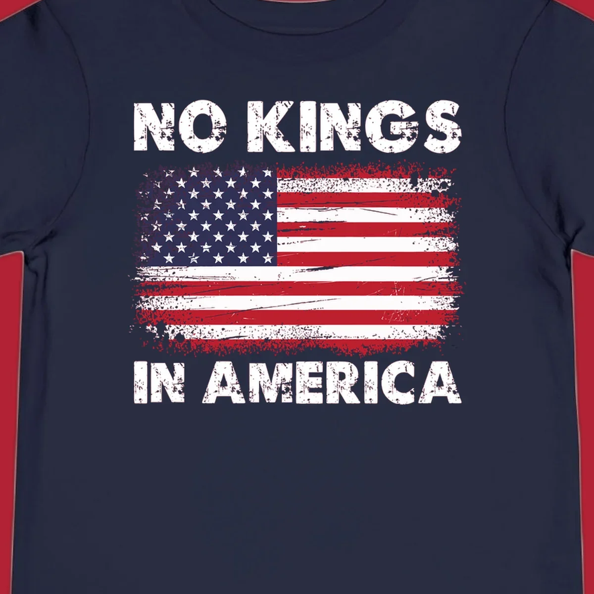 A distressed American flag with the white text 'NO KINGS IN AMERICA' above and below it.
