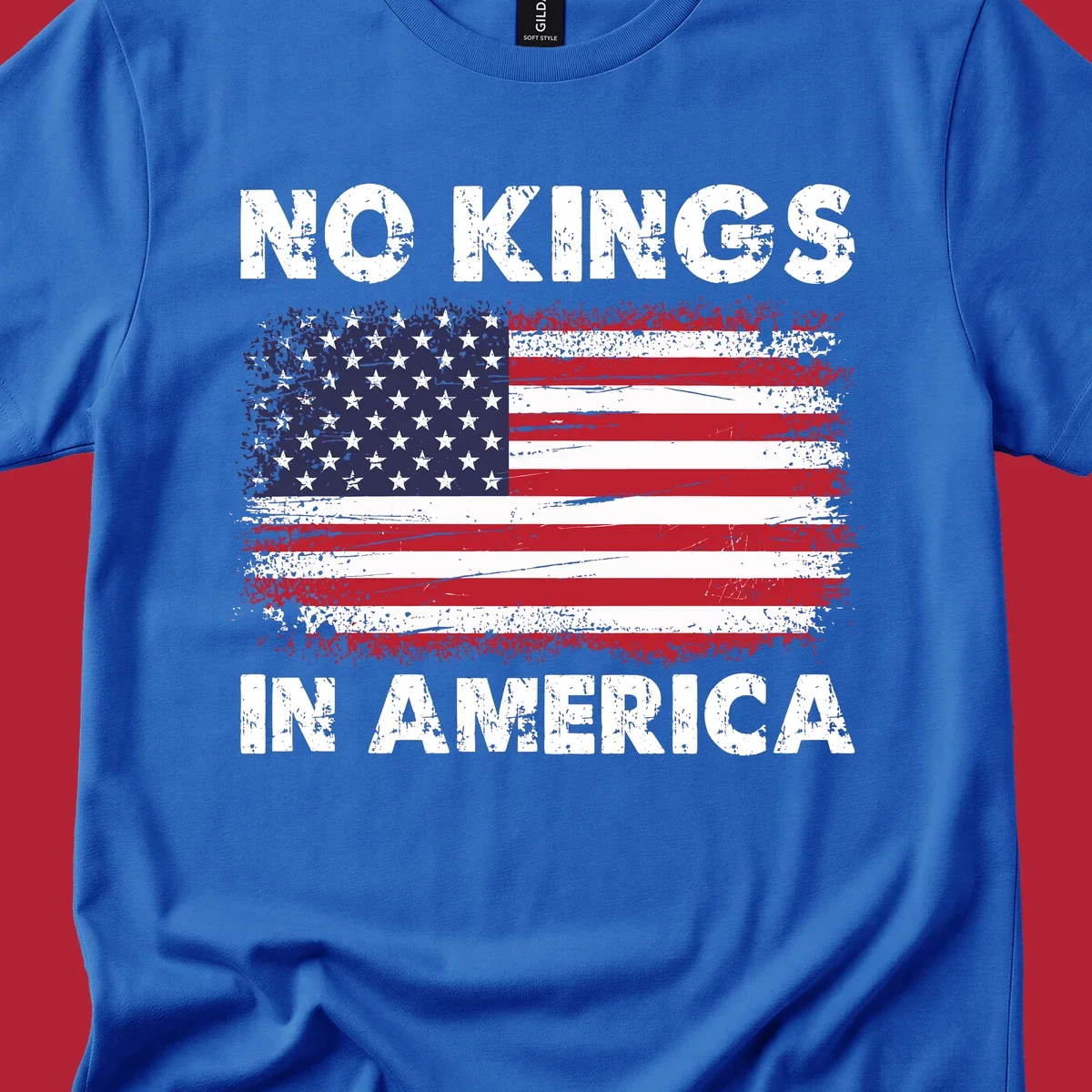 A distressed American flag with the white text 'NO KINGS IN AMERICA' above and below it.