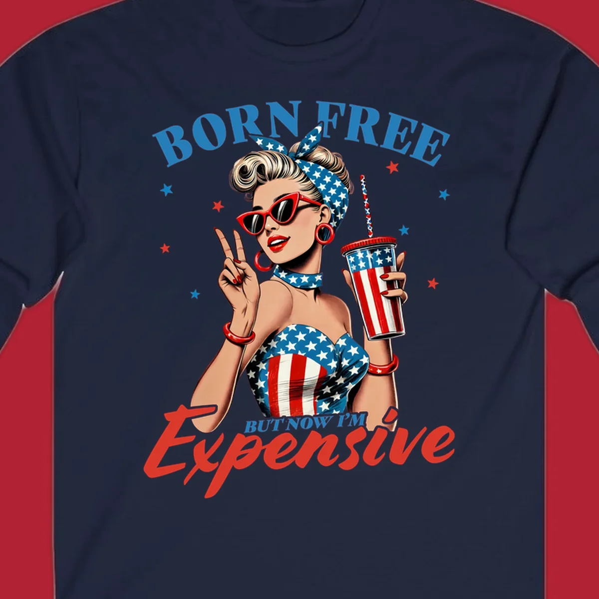 A vintage pin-up girl with a patriotic outfit and cup, making a peace sign, with the text "Born Free But Now I'm Expensive". This born-free-expensive-pinup design is surrounded by stars.