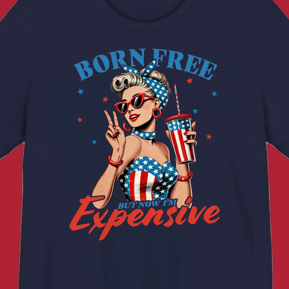 A vintage pin-up girl with a patriotic outfit and cup, making a peace sign, with the text "Born Free But Now I'm Expensive". This born-free-expensive-pinup design is surrounded by stars.
