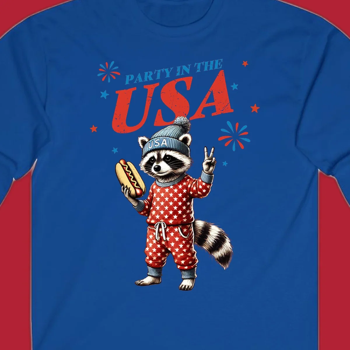 A cartoon raccoon wearing a USA beanie and star-patterned pajamas, holding a hotdog and making a peace sign, with 'PARTY IN THE USA' text and fireworks.