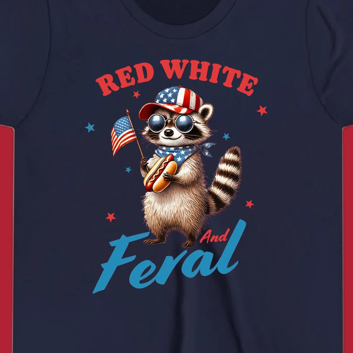 A cartoon raccoon wearing a patriotic hat and bandana, holding an American flag and a hot dog, with 'Red White And Feral' text. This is a red-white-feral-raccoon design.