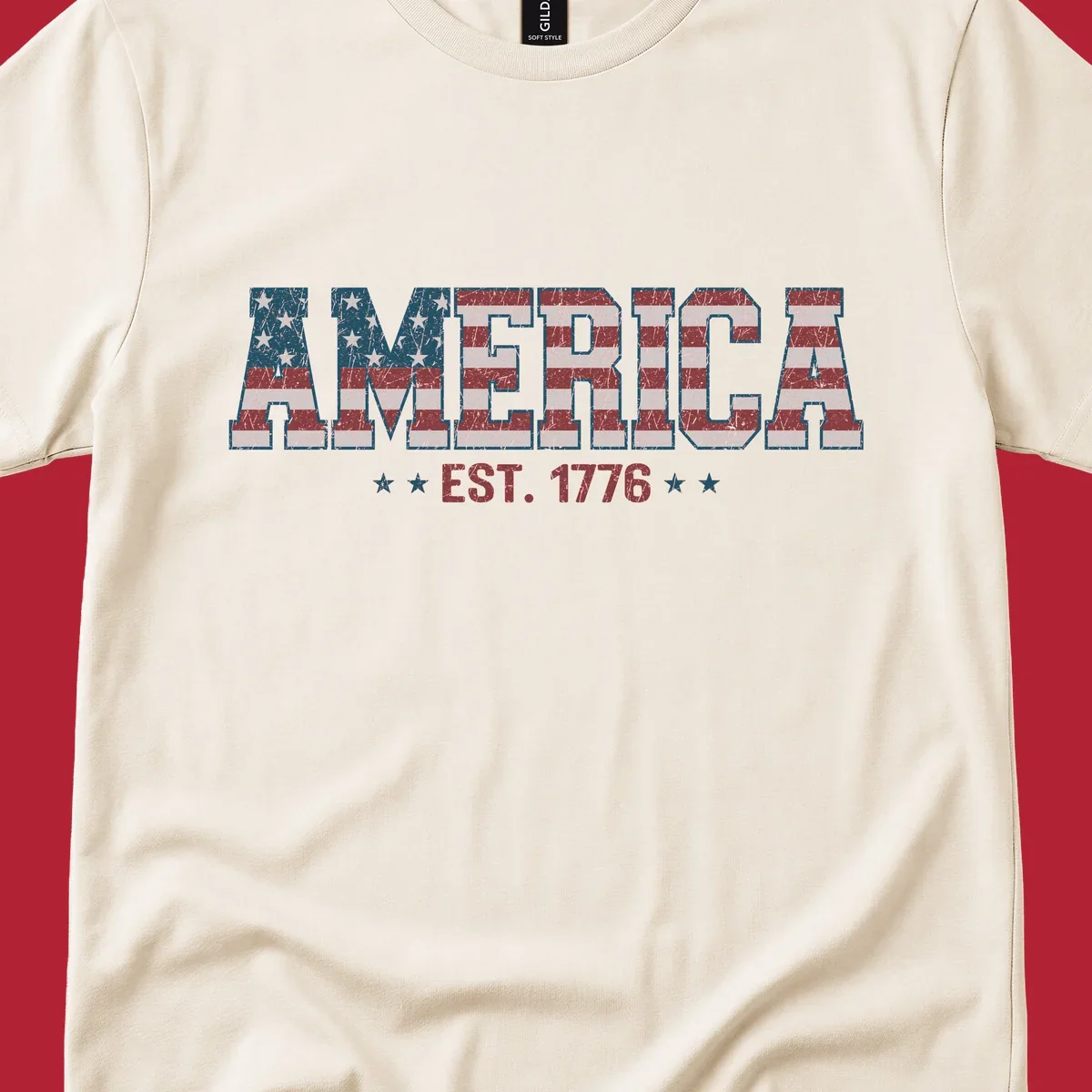 Distressed America Est. 1776 flag design with red, white, and blue flag pattern on block letters and stars.