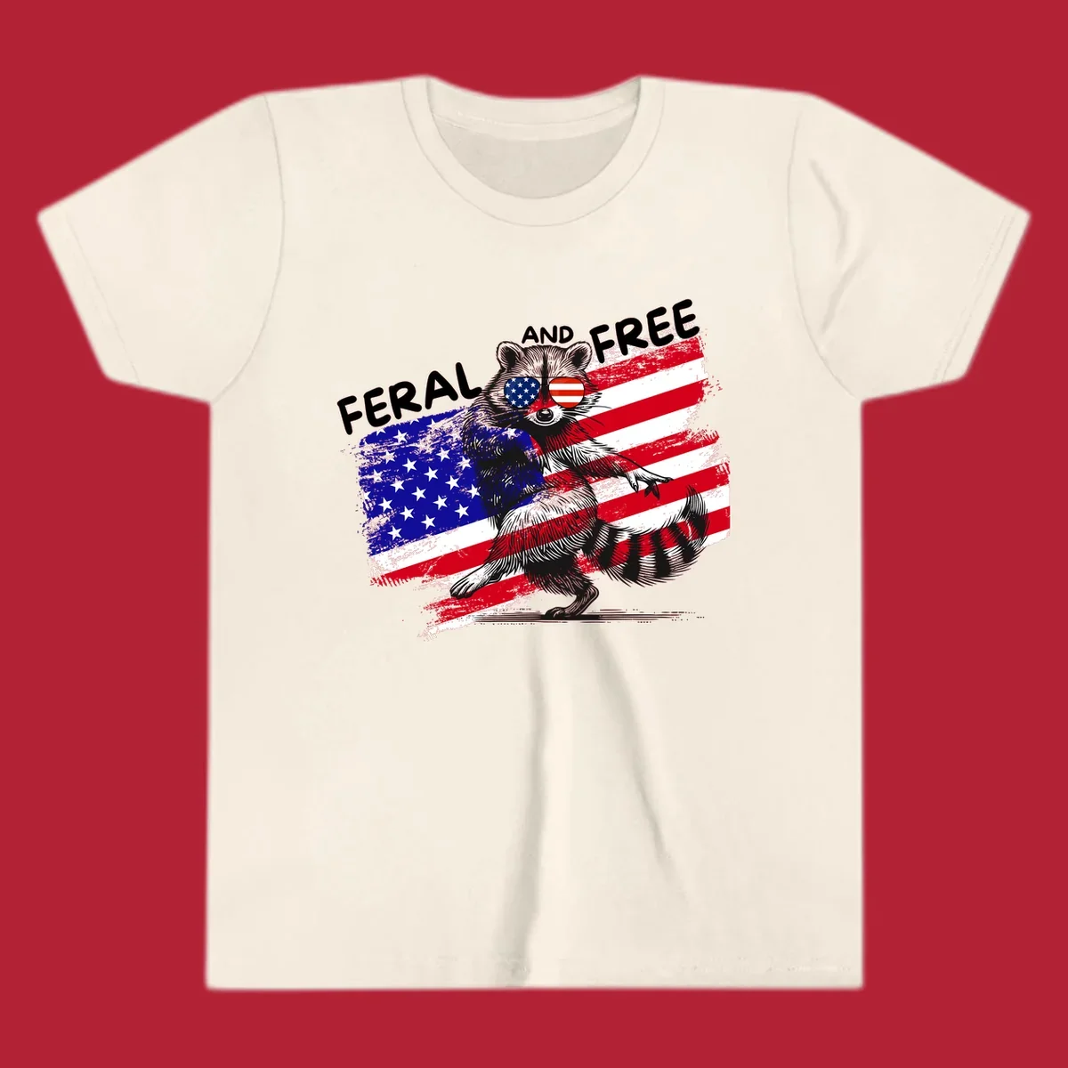 A standing raccoon with an American flag design and USA flag sunglasses, with the text 'FERAL AND FREE'. feral-free-raccoon-flag.
