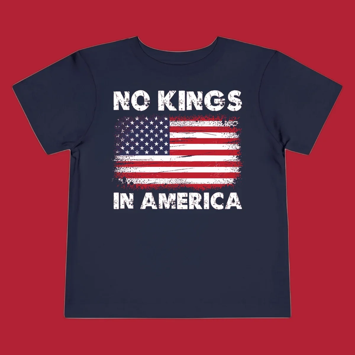 A distressed American flag with the white text 'NO KINGS IN AMERICA' above and below it.