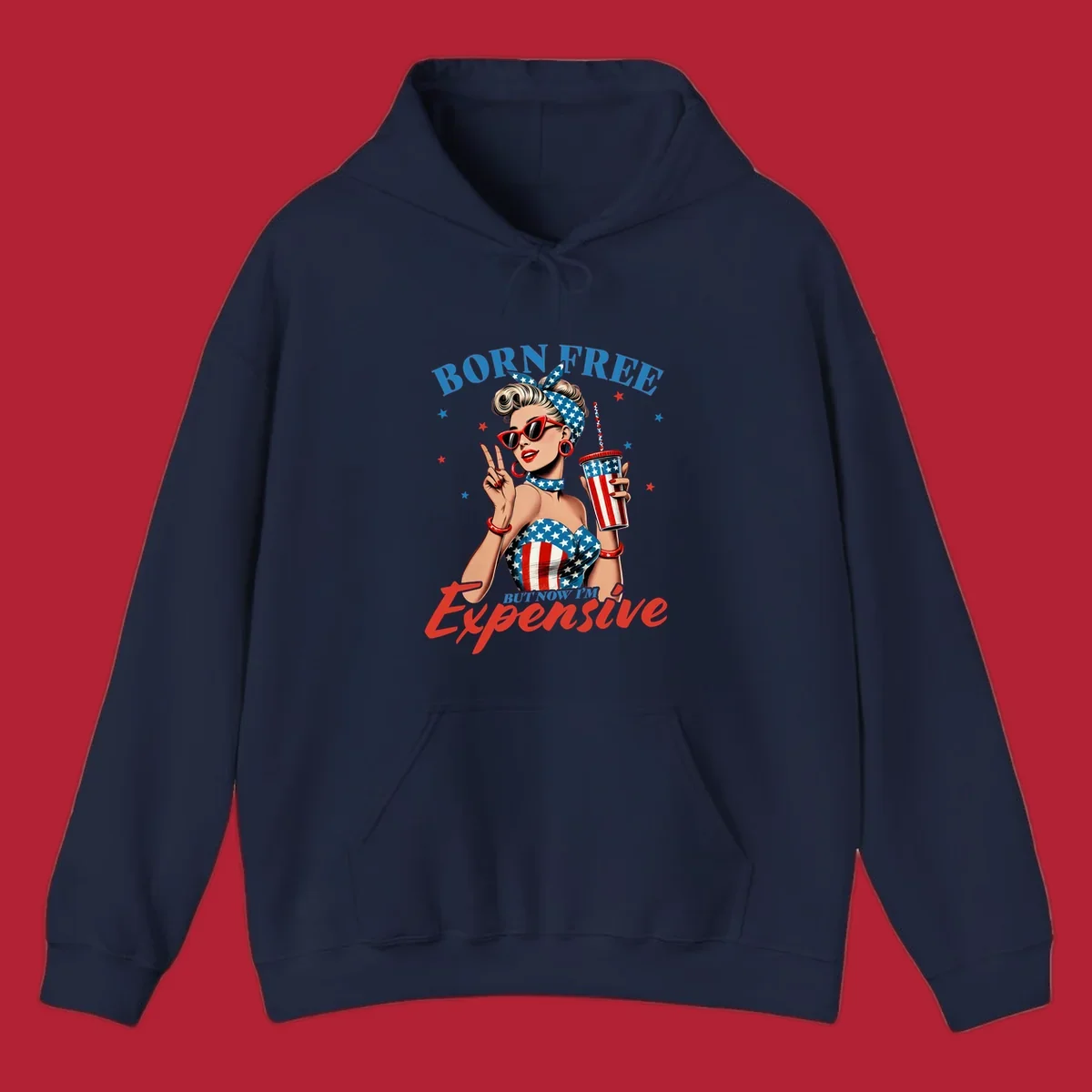 A vintage pin-up girl with a patriotic outfit and cup, making a peace sign, with the text "Born Free But Now I'm Expensive". This born-free-expensive-pinup design is surrounded by stars.
