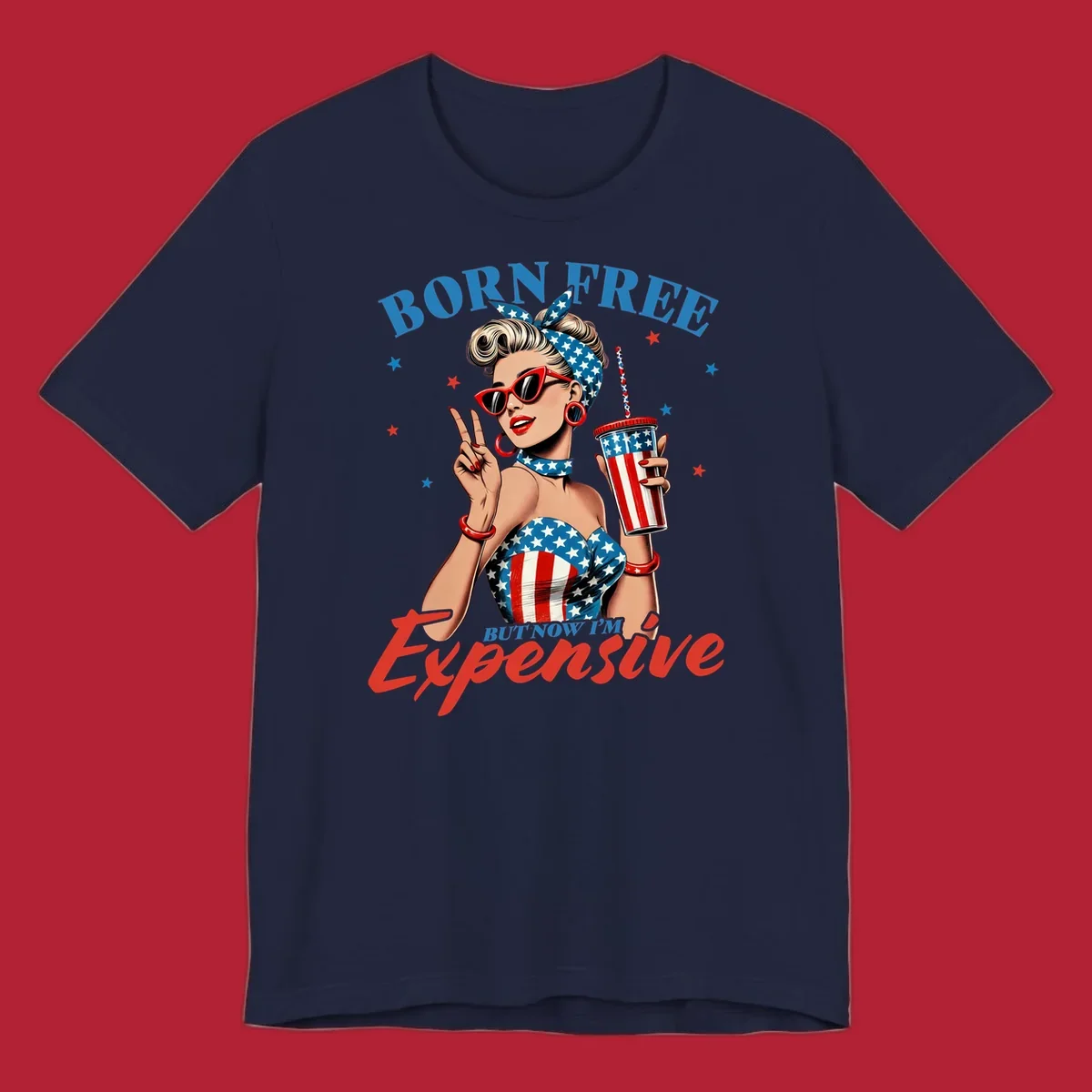 A vintage pin-up girl with a patriotic outfit and cup, making a peace sign, with the text "Born Free But Now I'm Expensive". This born-free-expensive-pinup design is surrounded by stars.