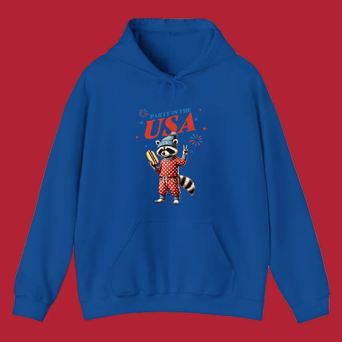 A cartoon raccoon wearing a USA beanie and star-patterned pajamas, holding a hotdog and making a peace sign, with 'PARTY IN THE USA' text and fireworks.